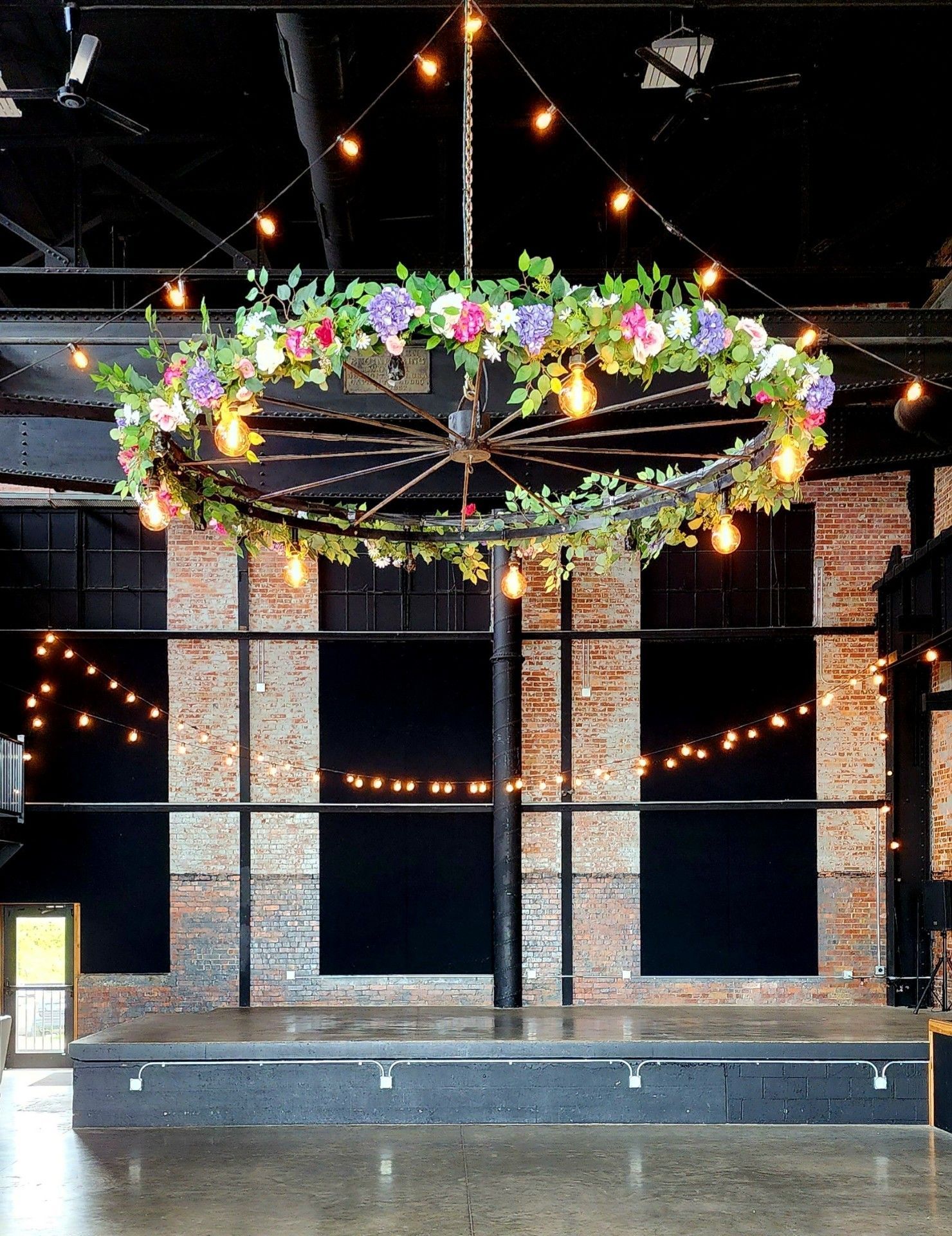A large chandelier with flowers and lights hanging from the ceiling