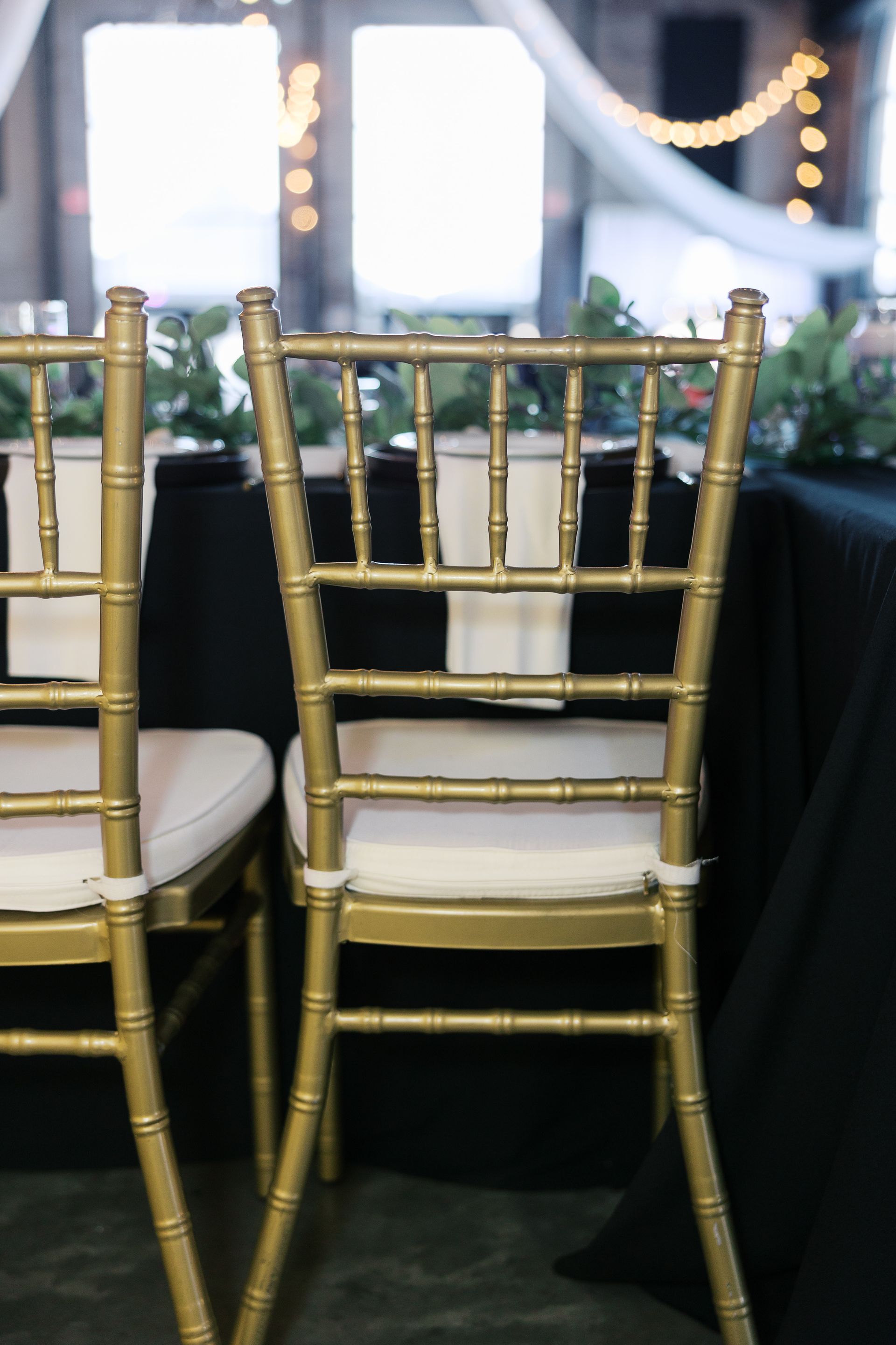 Two gold chairs are sitting next to each other on a table.