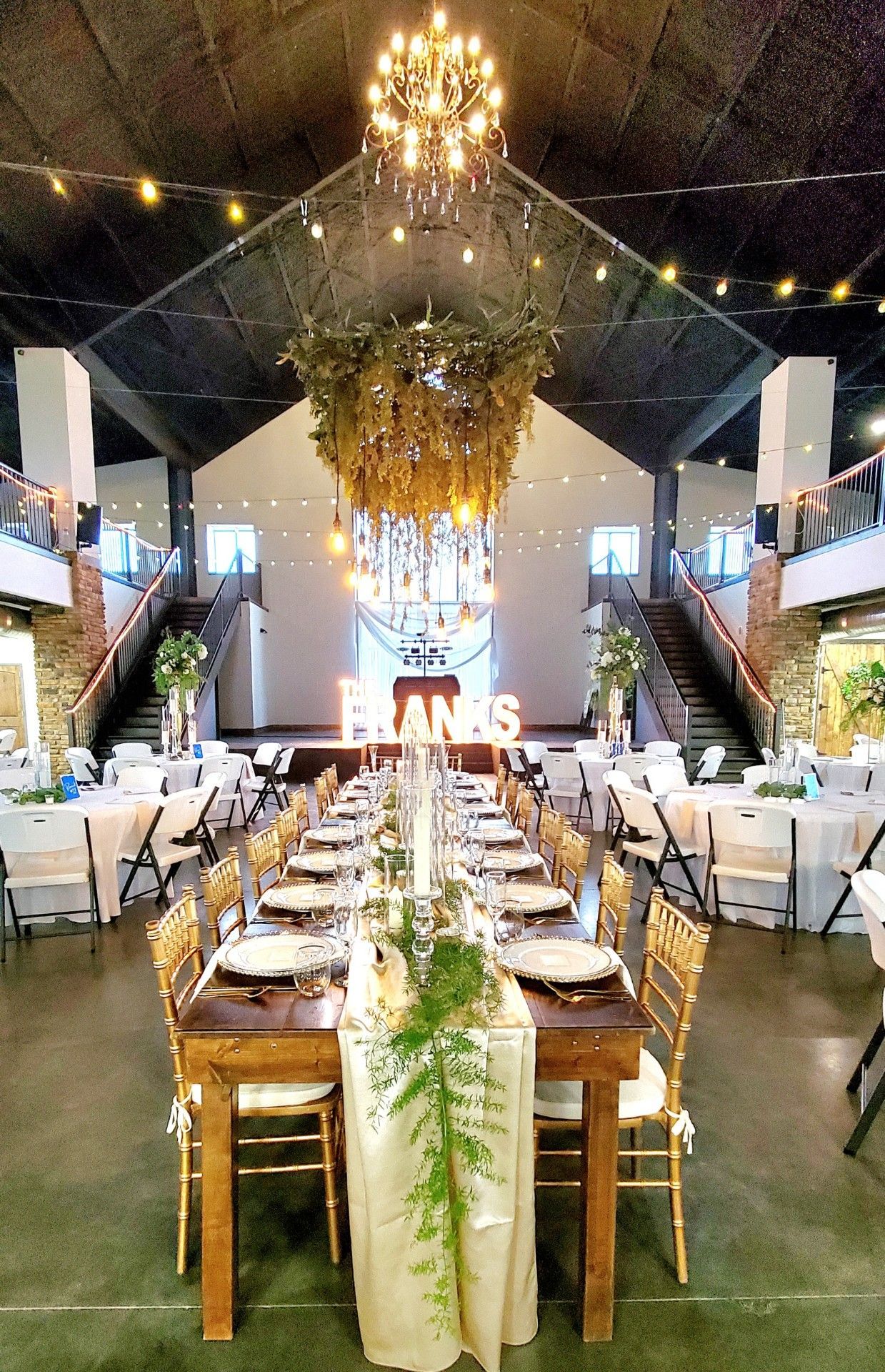 A large room with tables and chairs set up for a wedding reception.