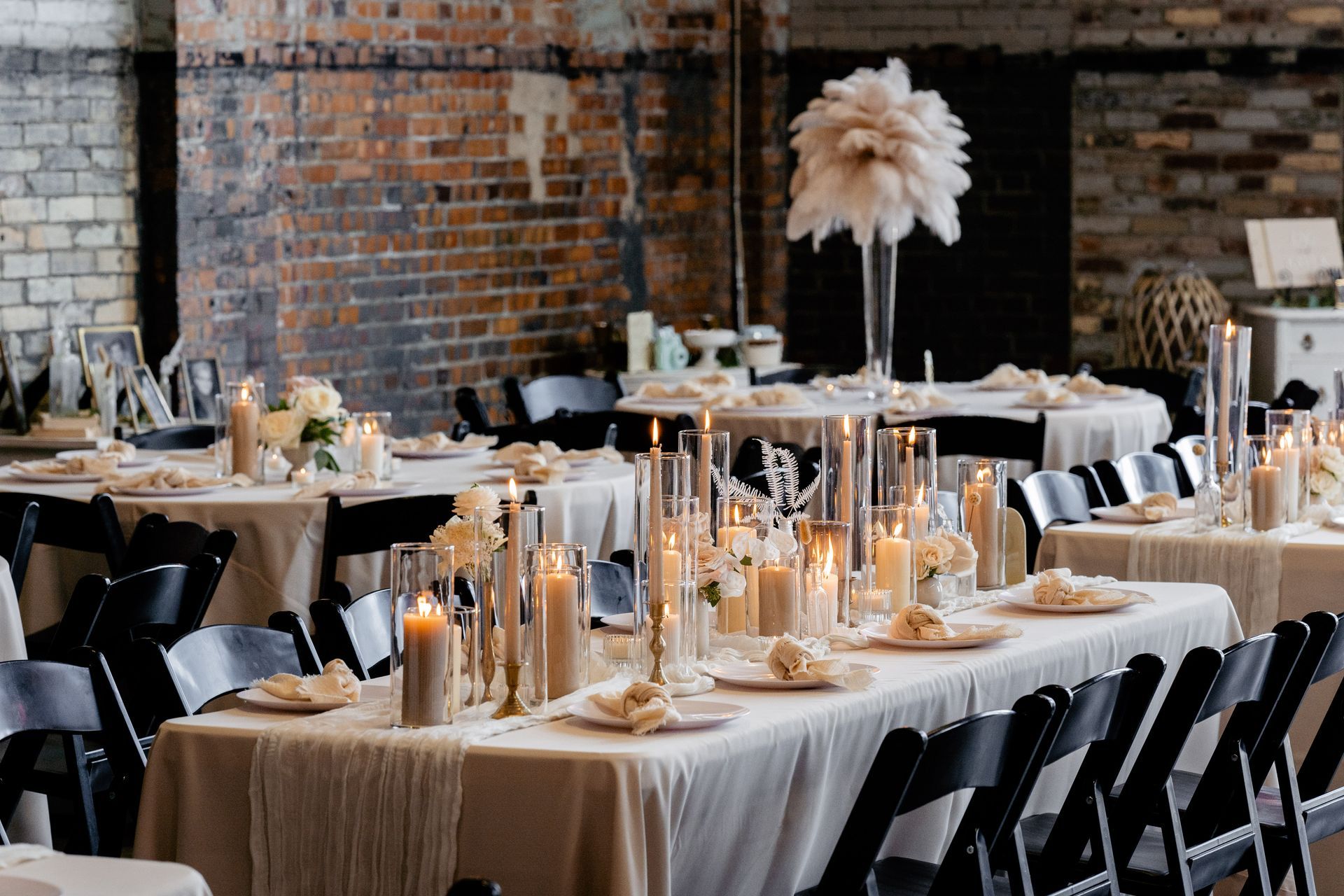 A long table with candles and flowers on it is set up for a wedding reception.
