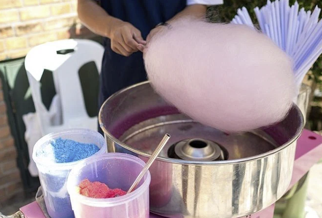 pink cotton candy being made in a cotton candy machine