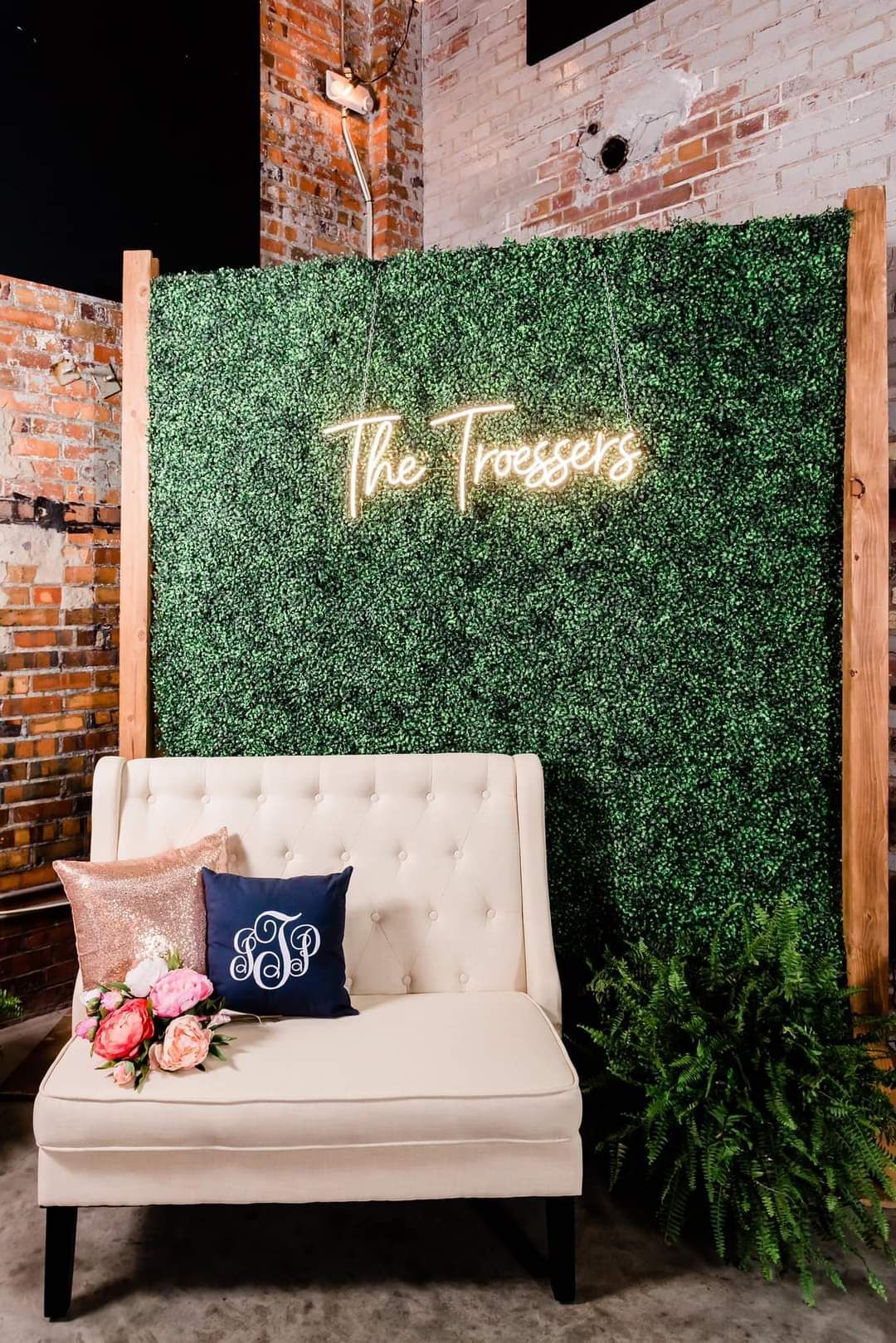 A white couch is sitting in front of a green wall.