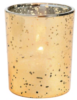 A gold candle holder with a candle inside of it