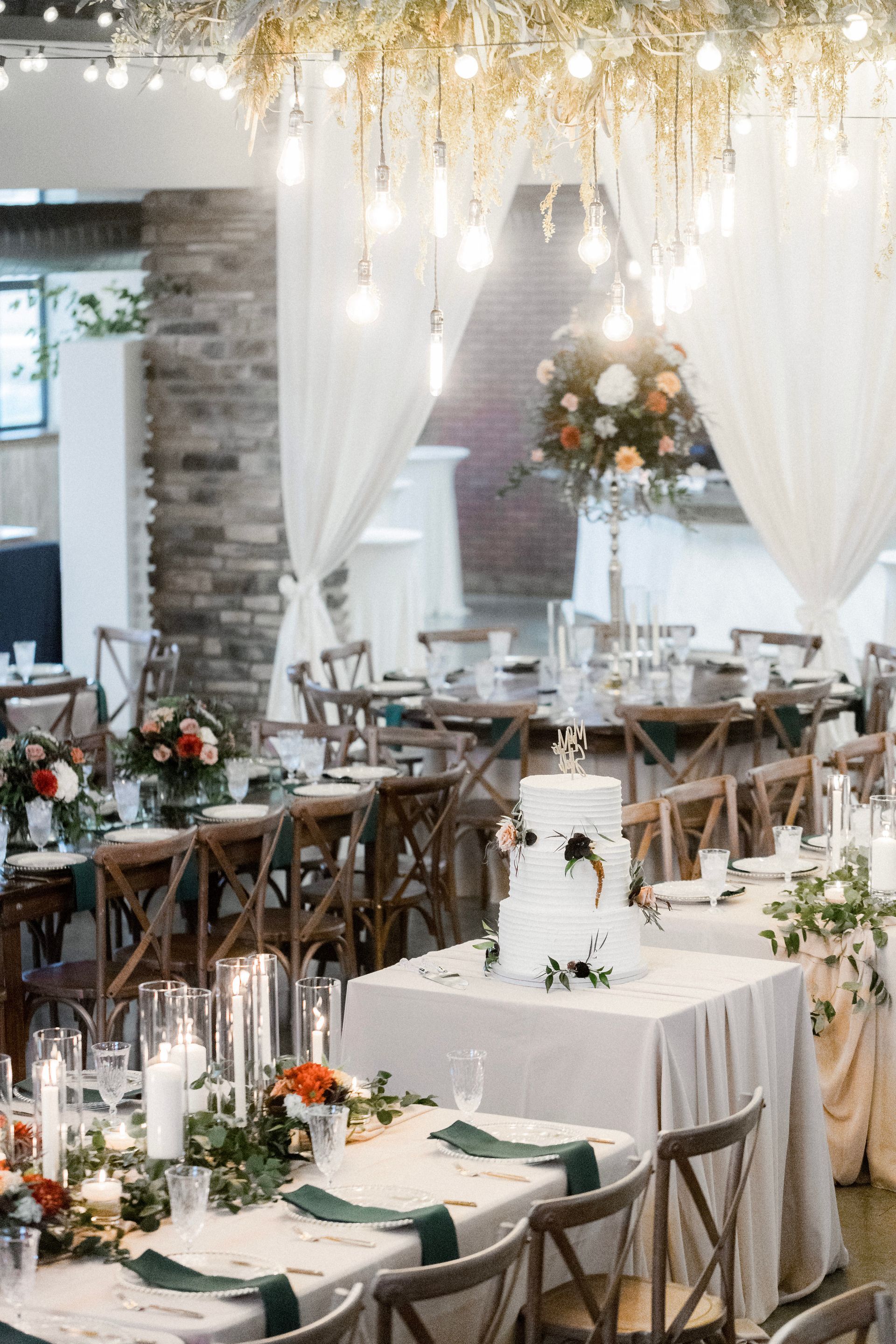 A large room with tables and chairs set up for a wedding reception.