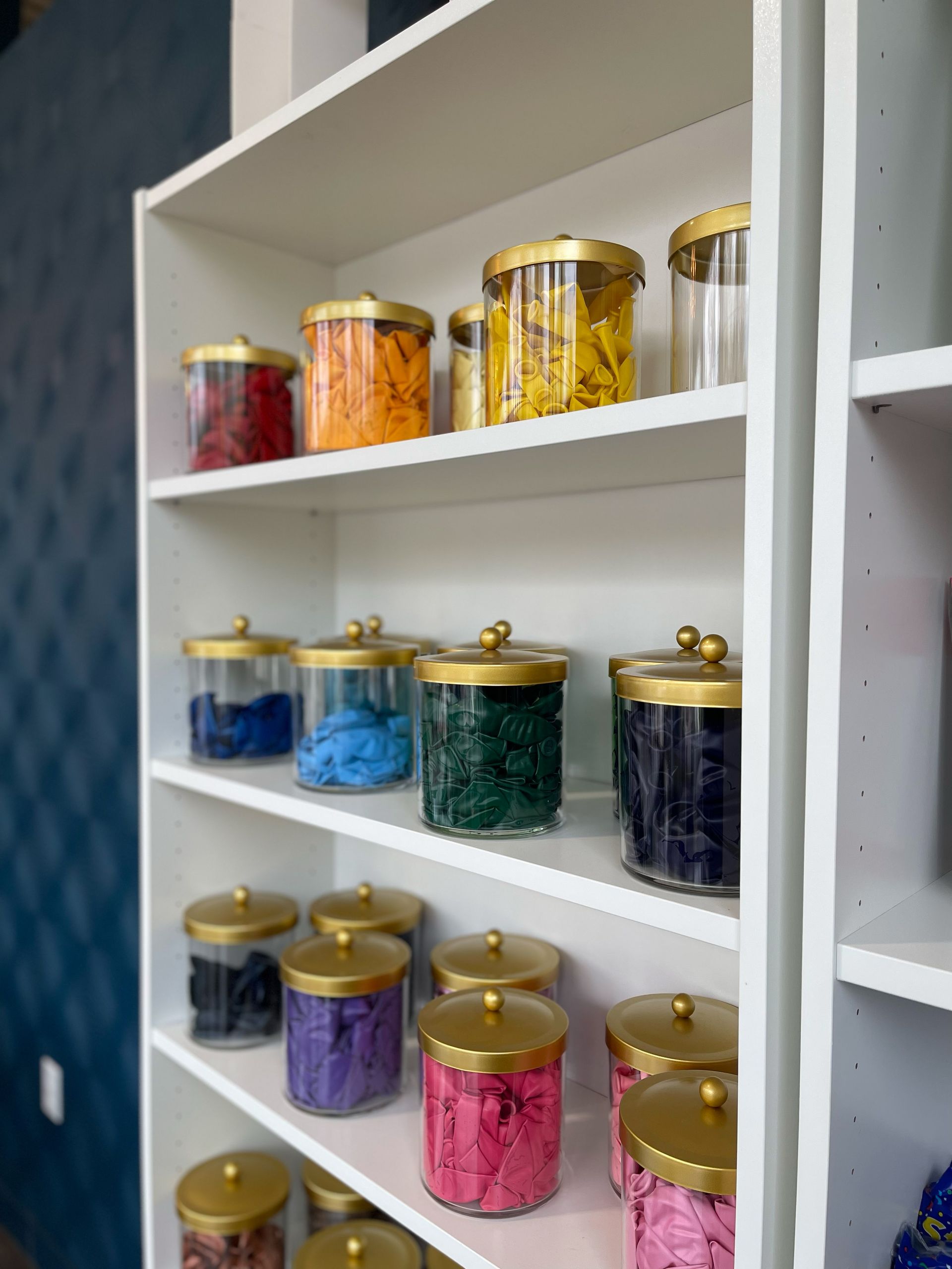 A shelf filled with jars of different colored yarn
