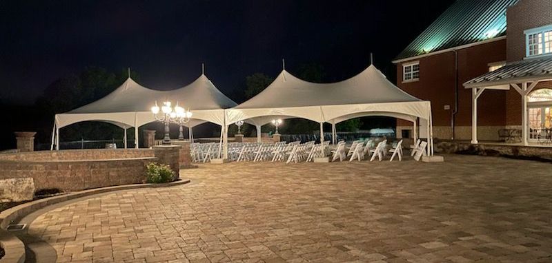 A group of tents are sitting on top of a brick patio at night.