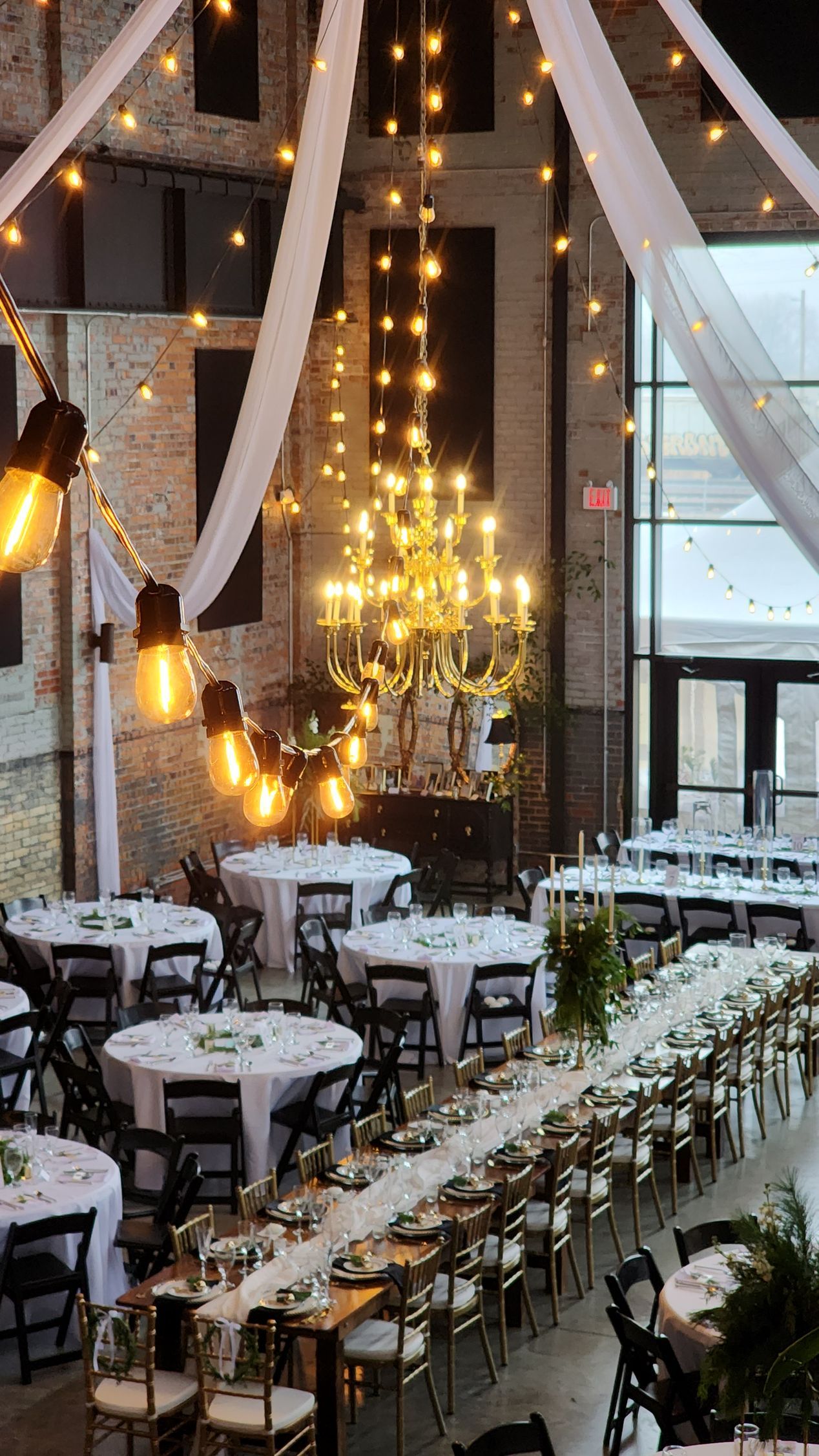A large room filled with tables and chairs and a chandelier.