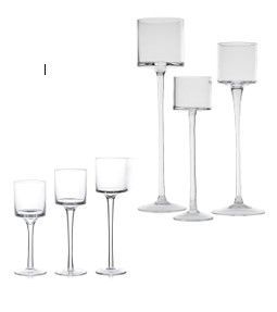 A group of clear glass candle holders of different sizes on a white background.