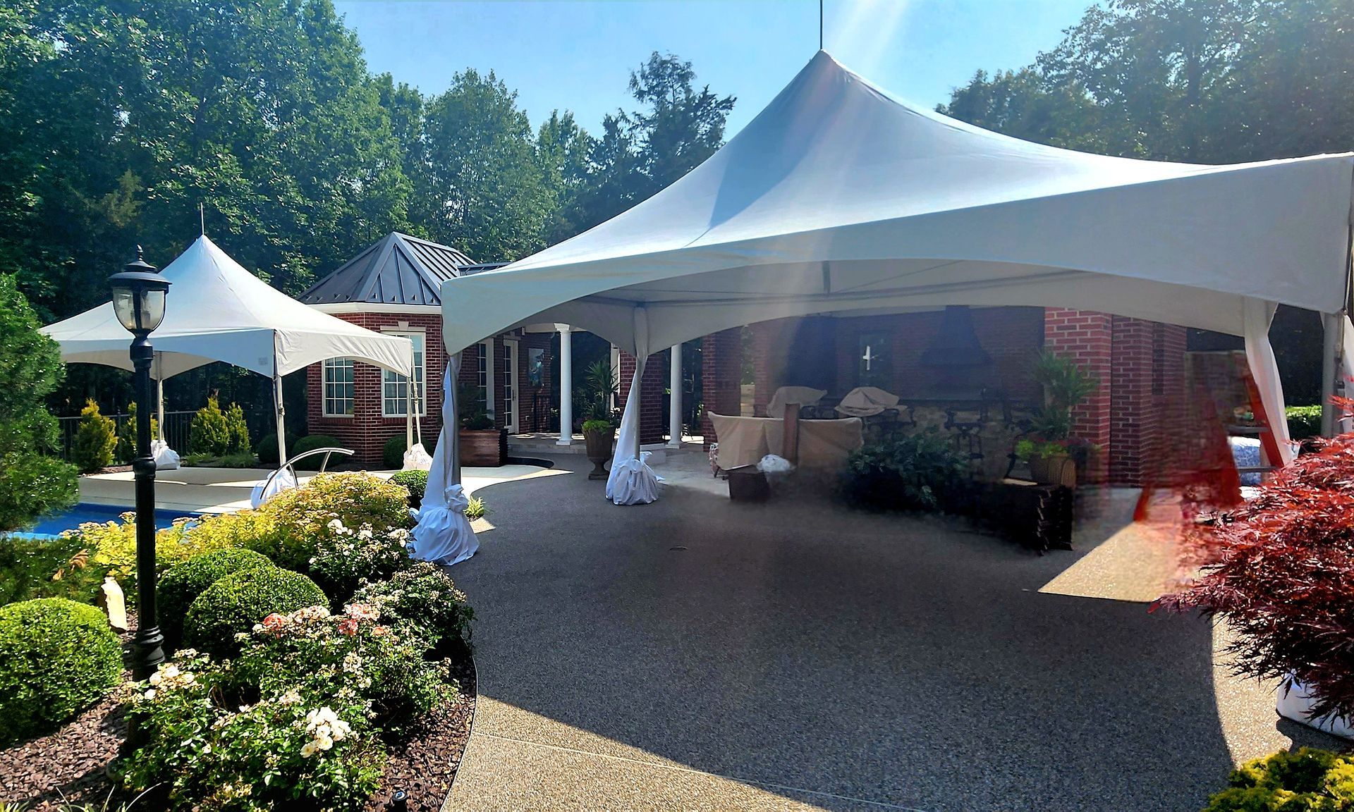 A large white tent is sitting in front of a house
