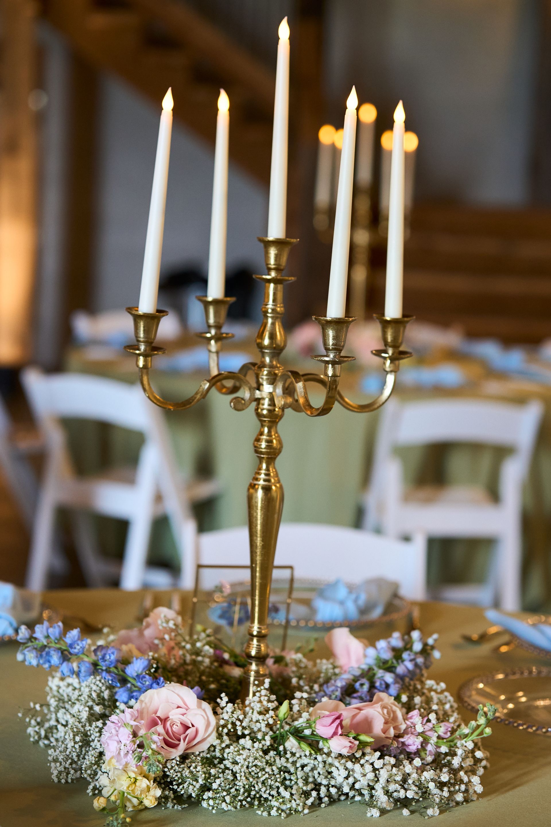 A candelabra with candles and flowers on a table.