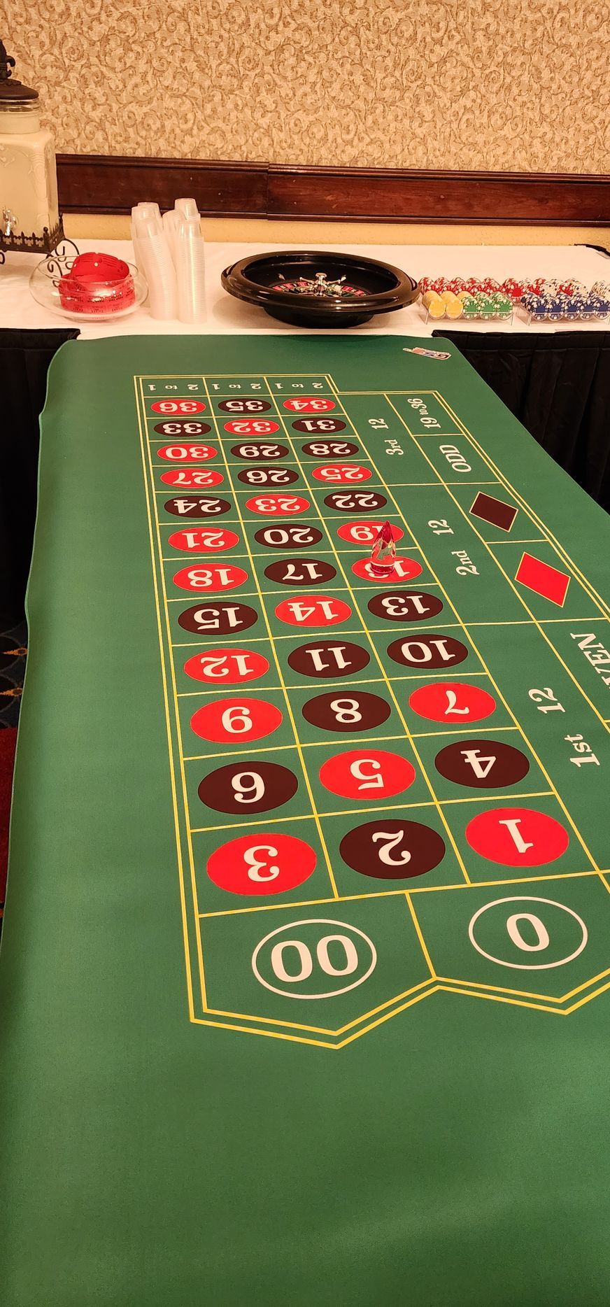 A roulette table is sitting on top of a table in a room.