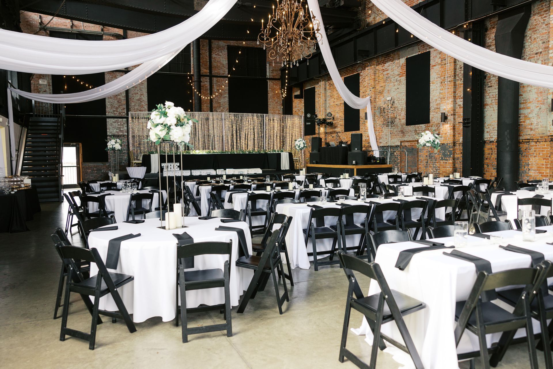 A large room with tables and chairs set up for a wedding reception.