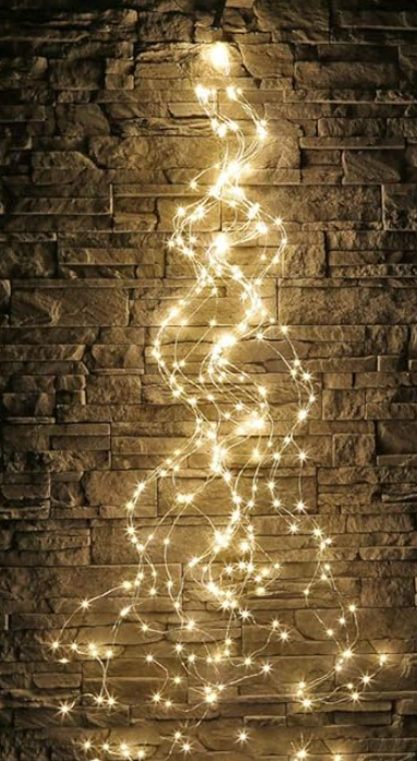 A string of lights is hanging on a brick wall.