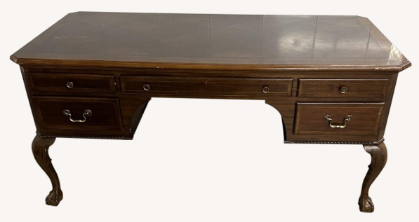 A wooden desk with four drawers on a white background