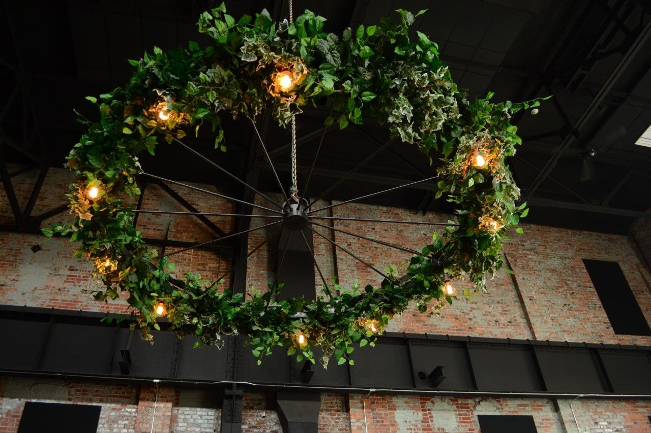 A large chandelier with leaves and lights hanging from the ceiling.