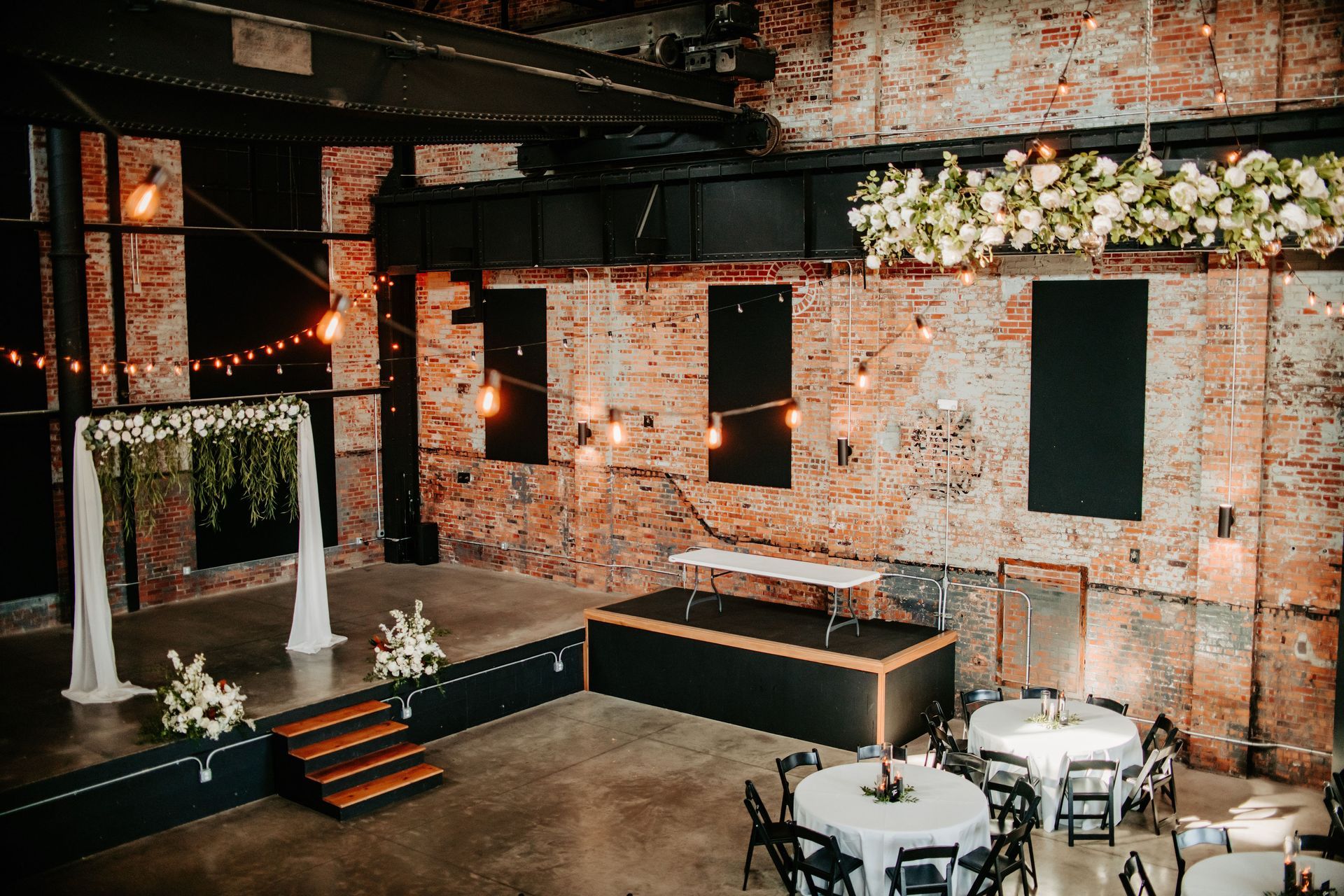 There is a stage in the middle of the room with tables and chairs.