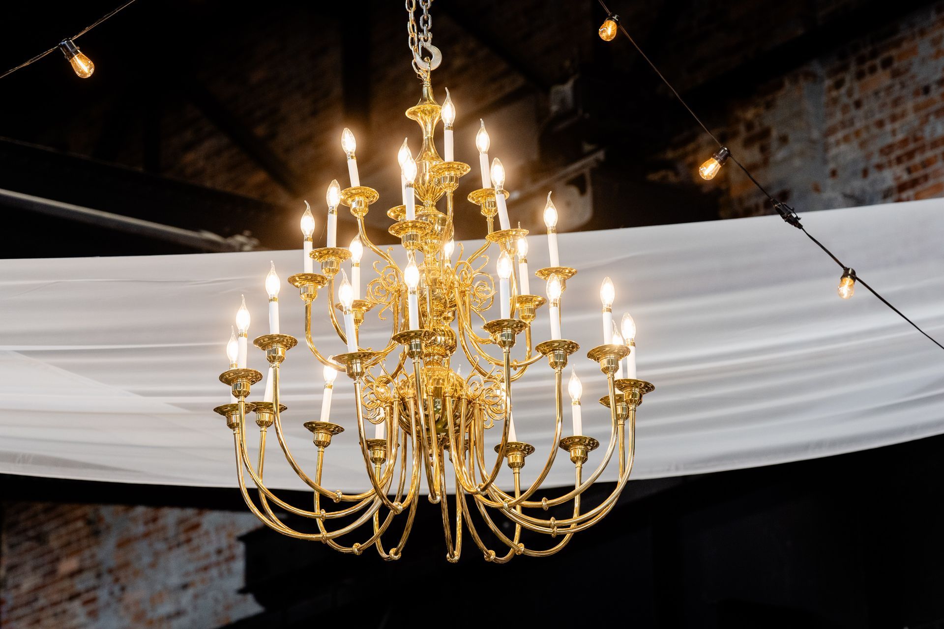 A large gold chandelier with many candles hanging from the ceiling.