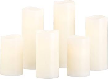 A group of white candles sitting next to each other on a white background.