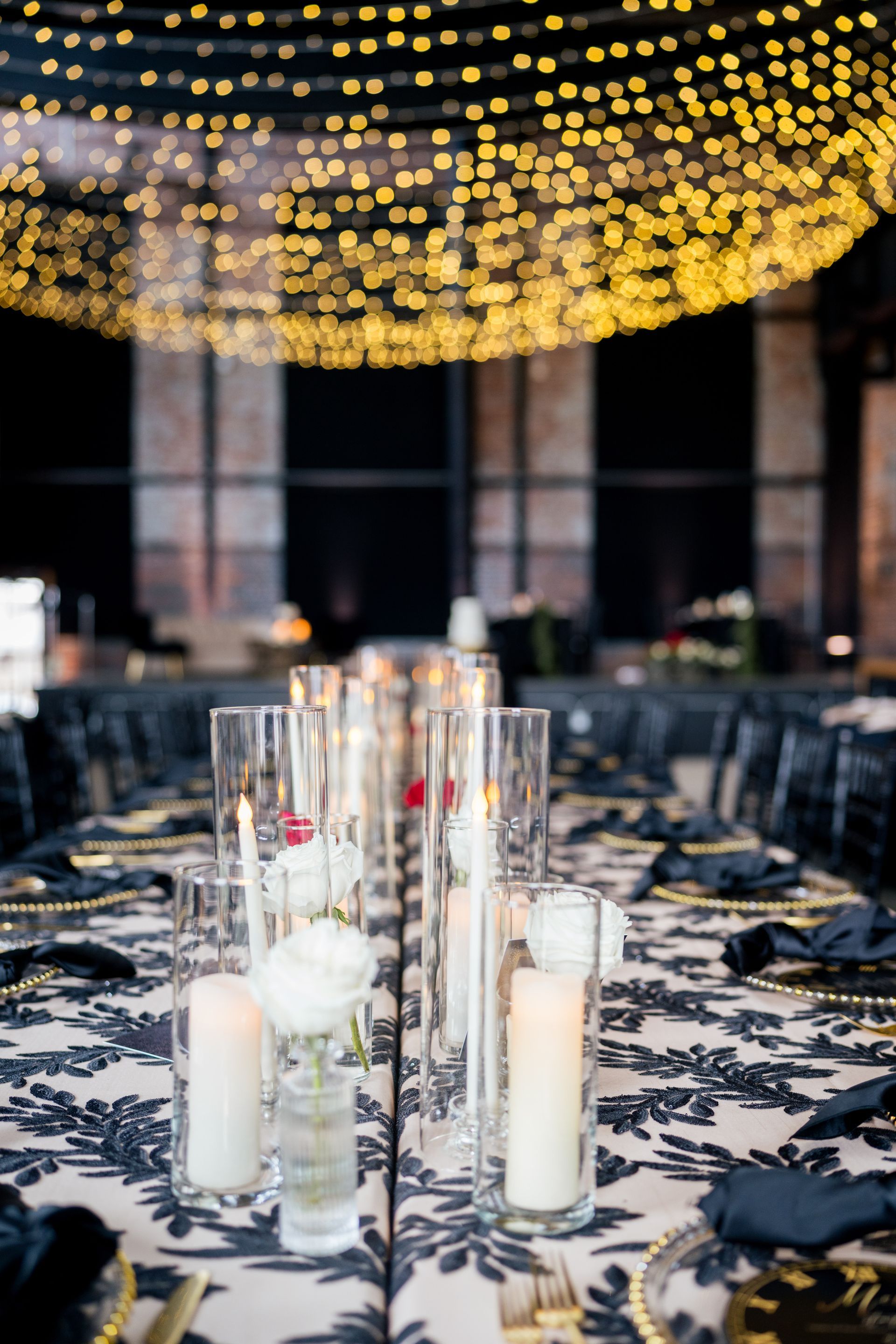 A table set for a wedding reception with candles and flowers on it.
