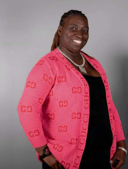 Construction worker in a hard hat and safety vest, writing on a clipboard at a construction site.