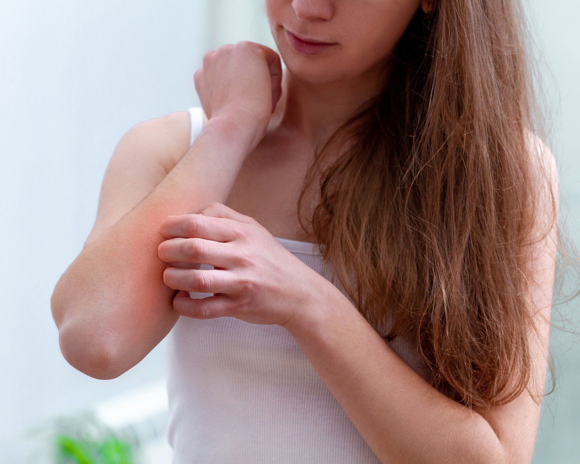 a woman is scratching her elbow in a bathroom .