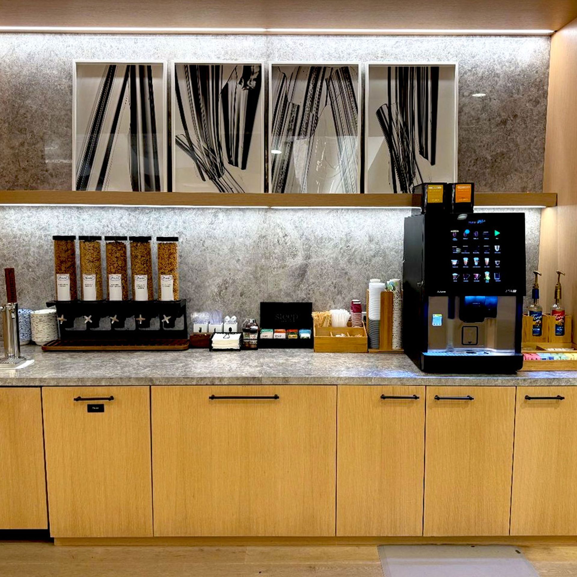 Modern coffee station with espresso machine, shelves, and a framed “Great coffee better days” sign
