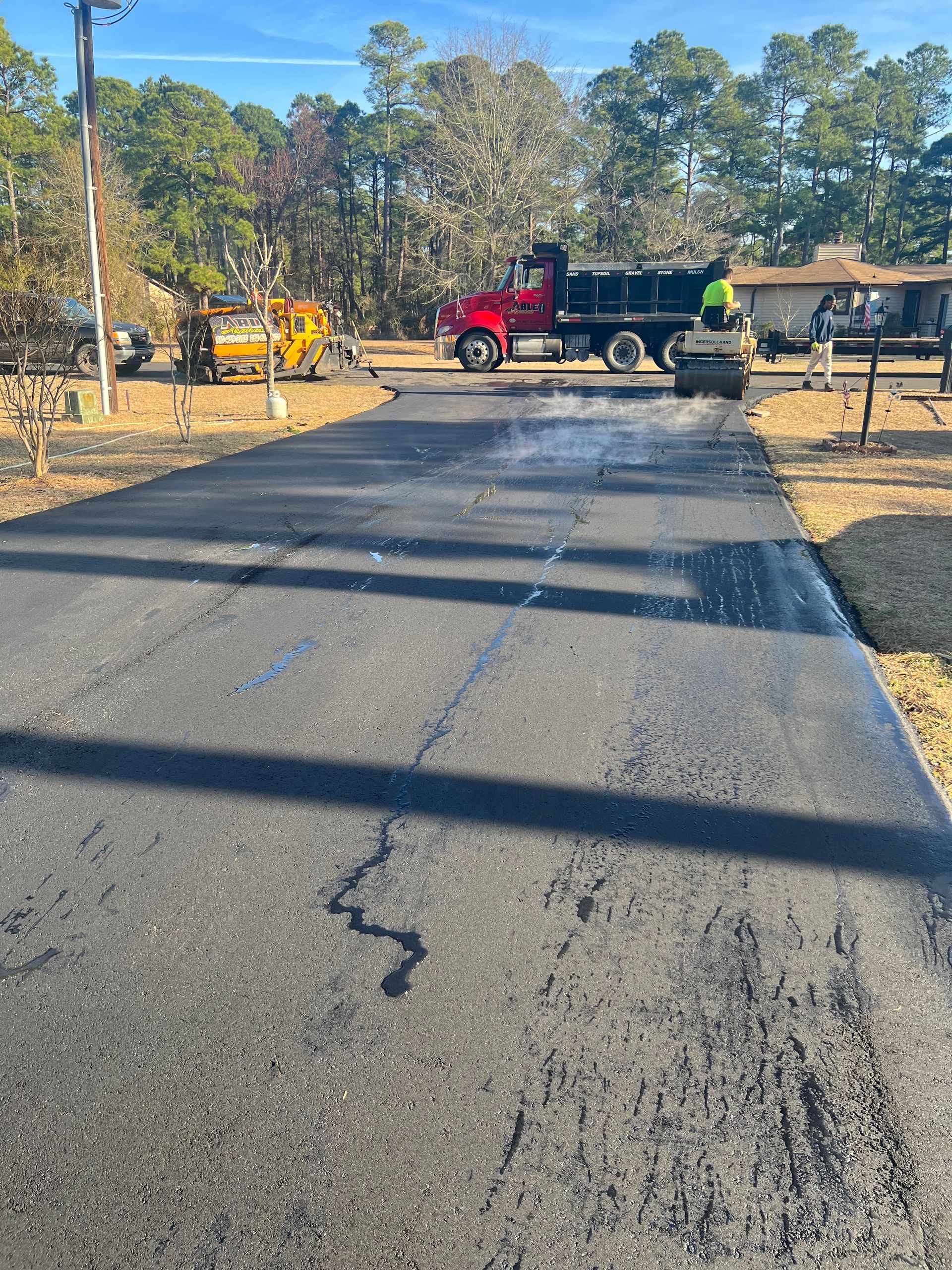 A red dump truck is parked on the side of a road.