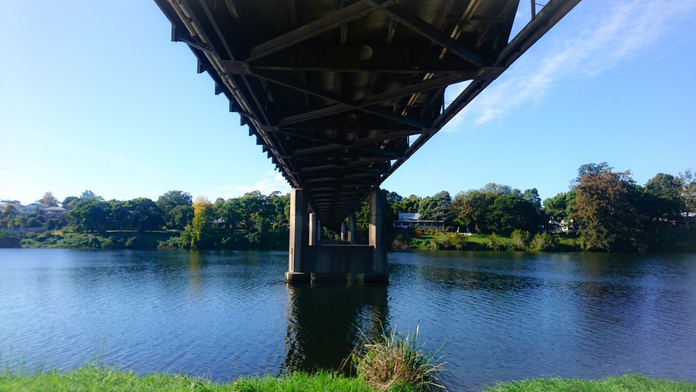 View From Under a Metal Bridge Over a River on a Sunny Day — Nambucca Concrete Pumping in Kempsey, NSW