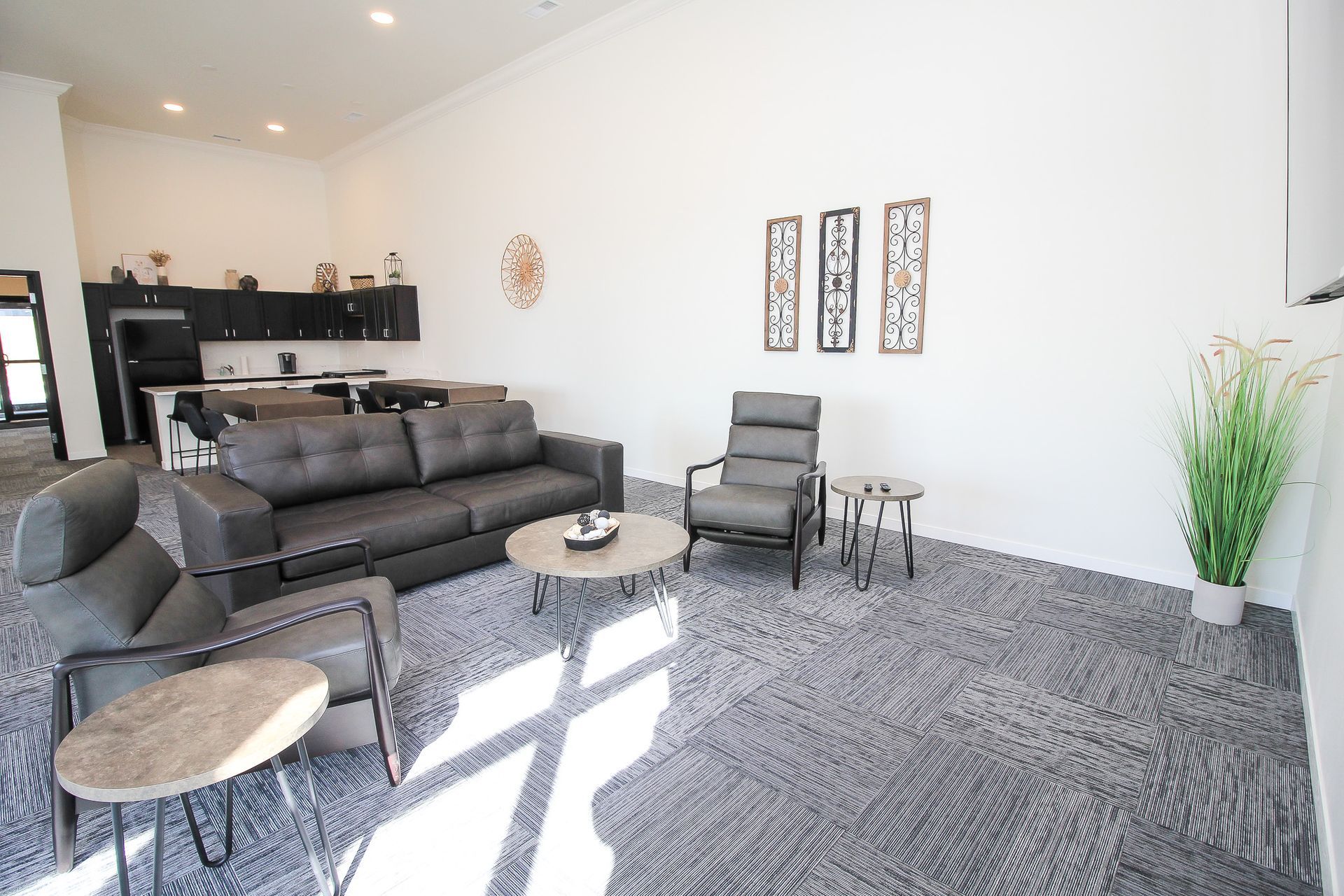 Modern living room with gray furniture, patterned rug, wall art, and sunlight on the floor