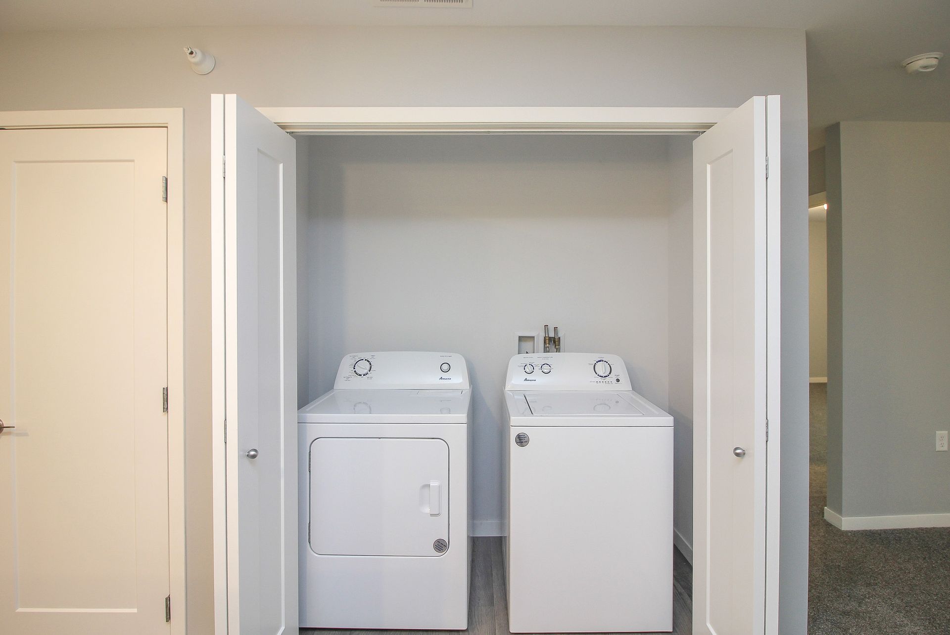 Laundry room with a white washer and dryer side by side in a closet alcove.