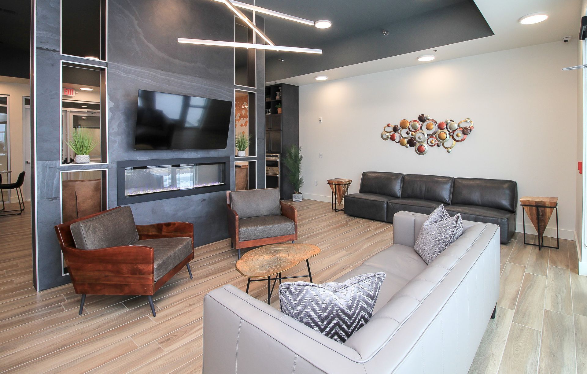 Modern lounge with gray massage chairs, wall-mounted TV, and large window overlooking water