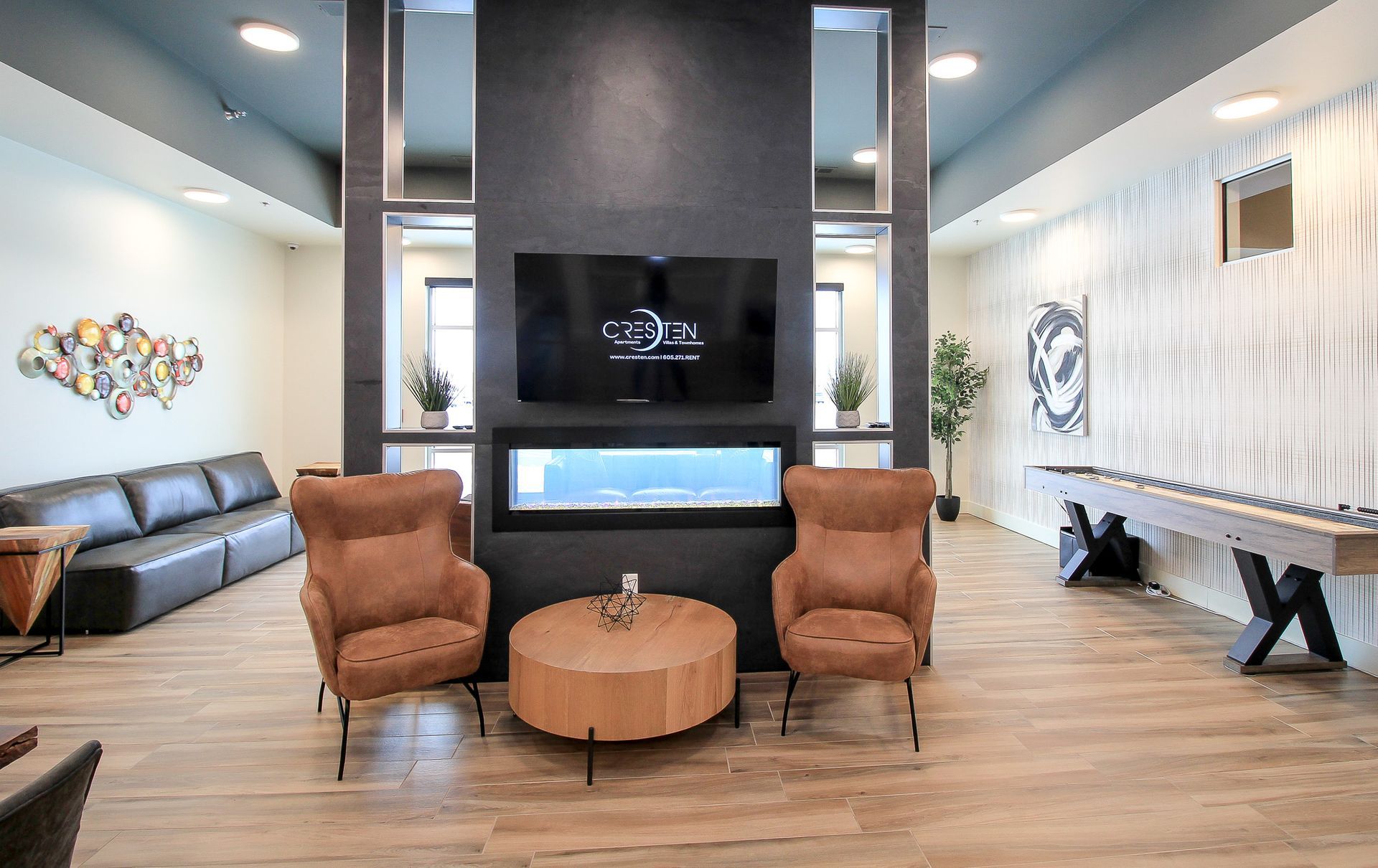 Modern café interior with wood floors, black ceiling, tables, chairs, and a central sink island