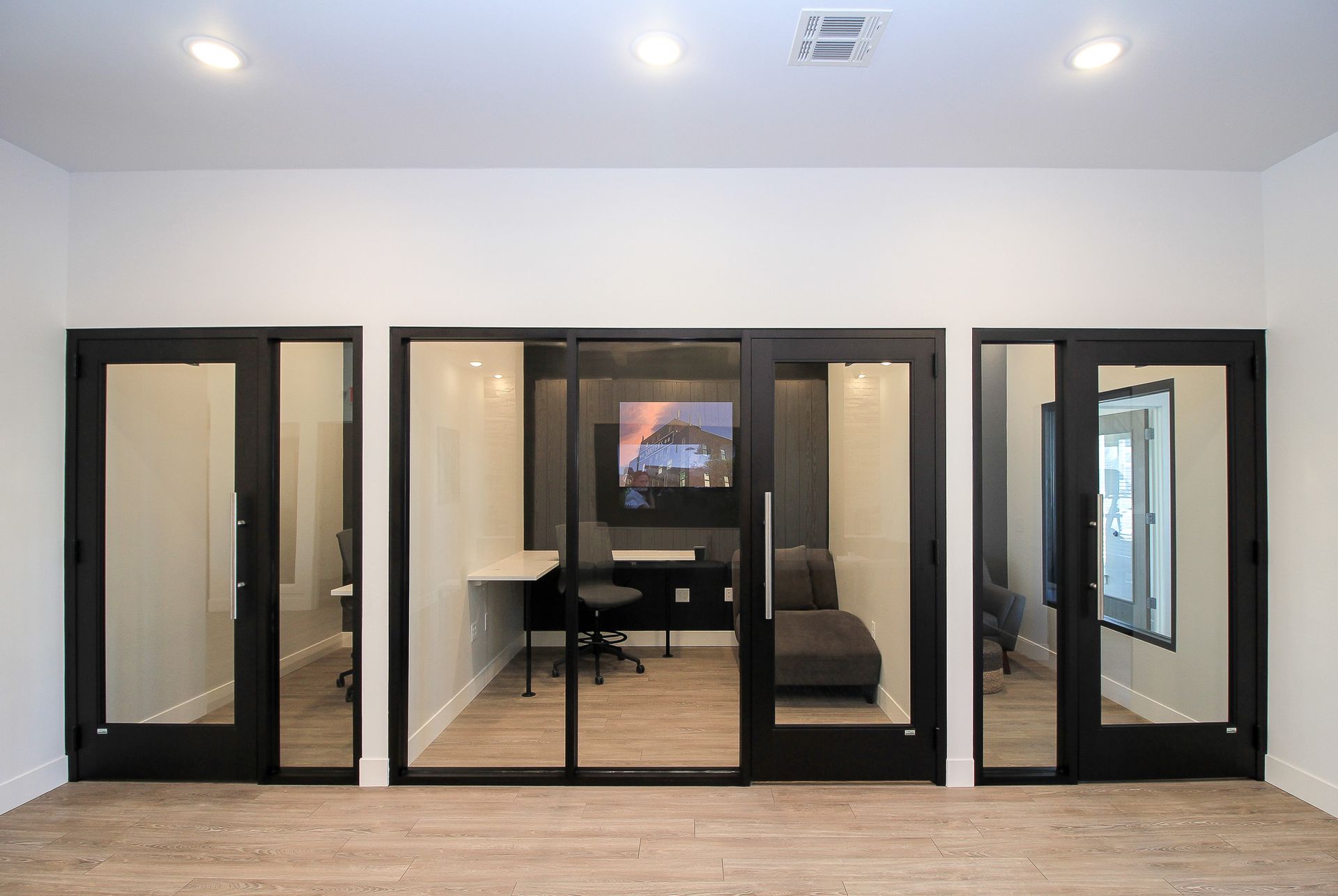 Modern office with black-framed glass doors and a central conference room view