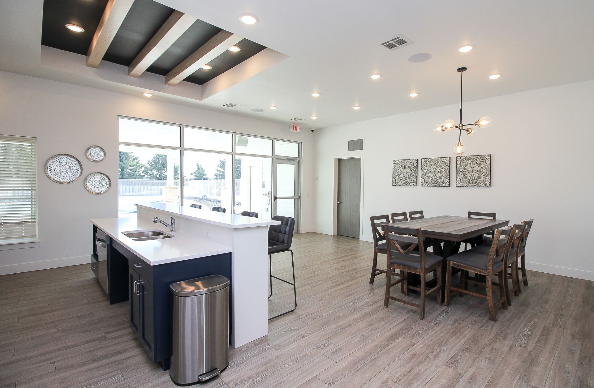 Modern open-concept kitchen and dining area with white island, wood flooring, and dark dining table