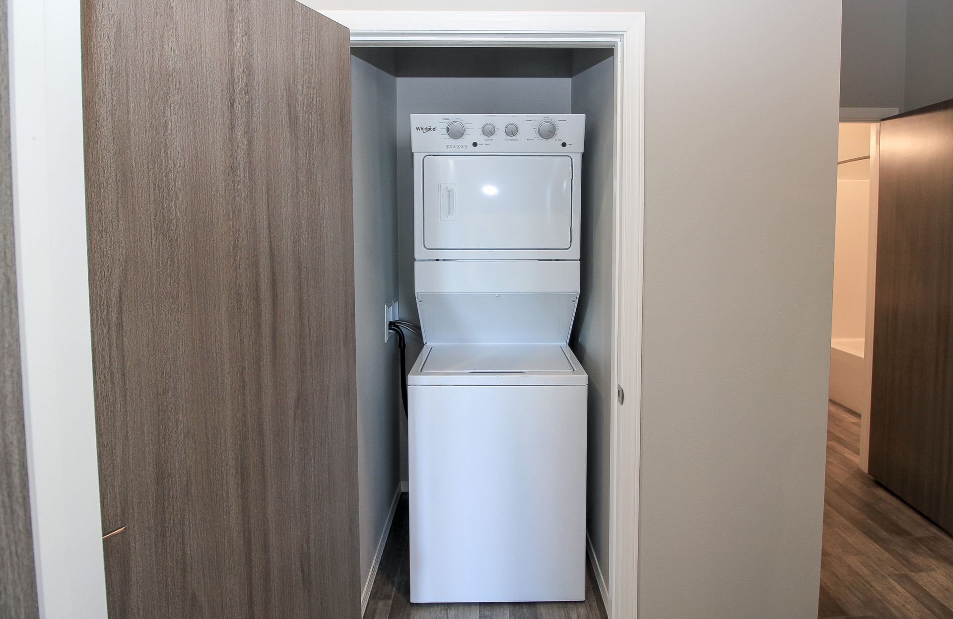 Stacked washer and dryer in a narrow closet with the doors open