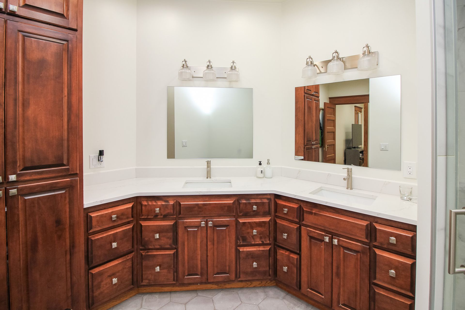 Spacious bathroom vanity with dark wood cabinets, double sinks, and two wall-mounted mirrors