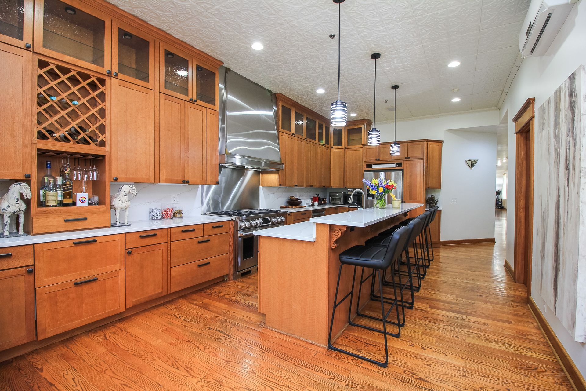 Spacious kitchen with wood cabinets, large island, bar stools, and stainless steel appliances