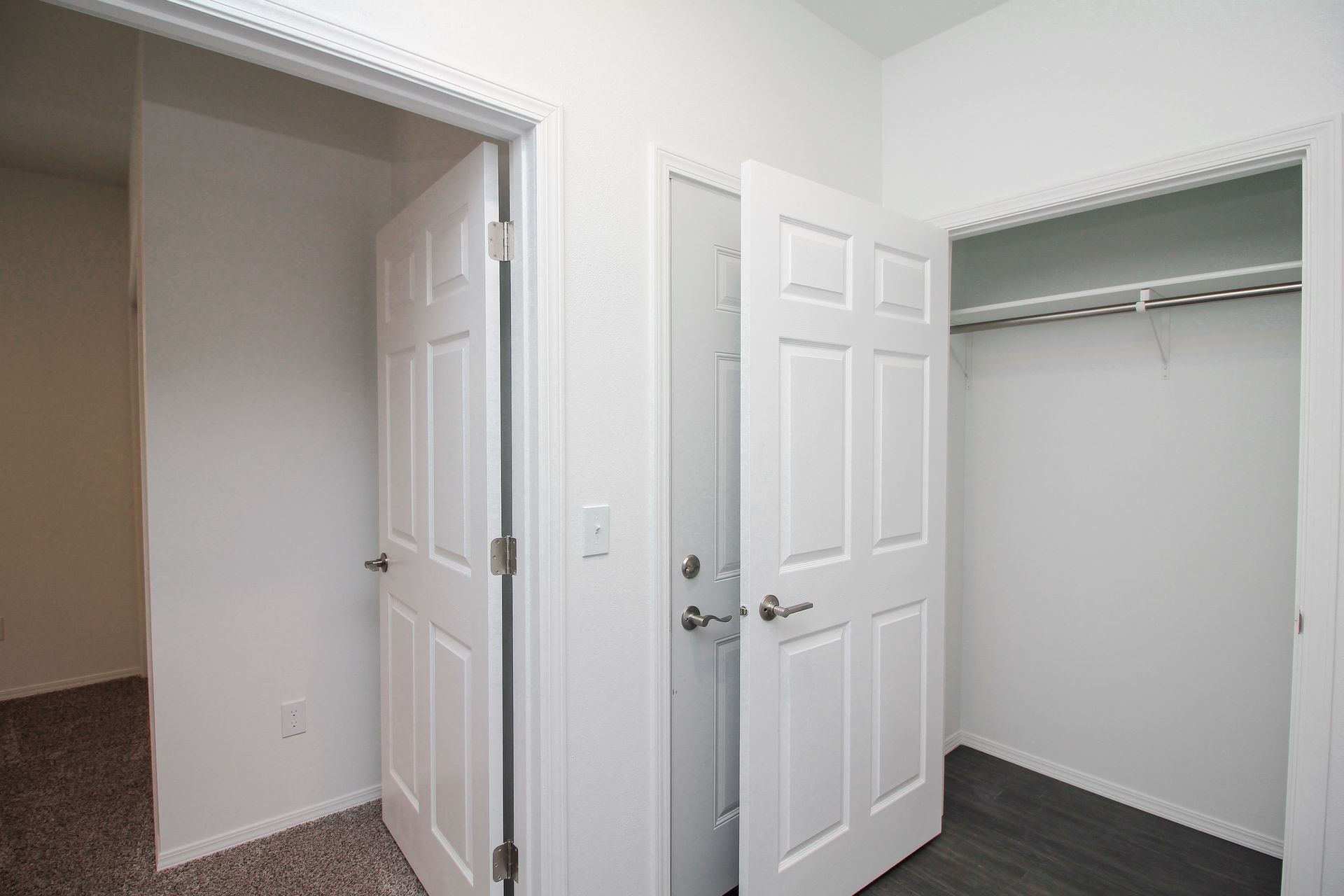 Open laundry closet with a white washer and dryer behind double doors.
