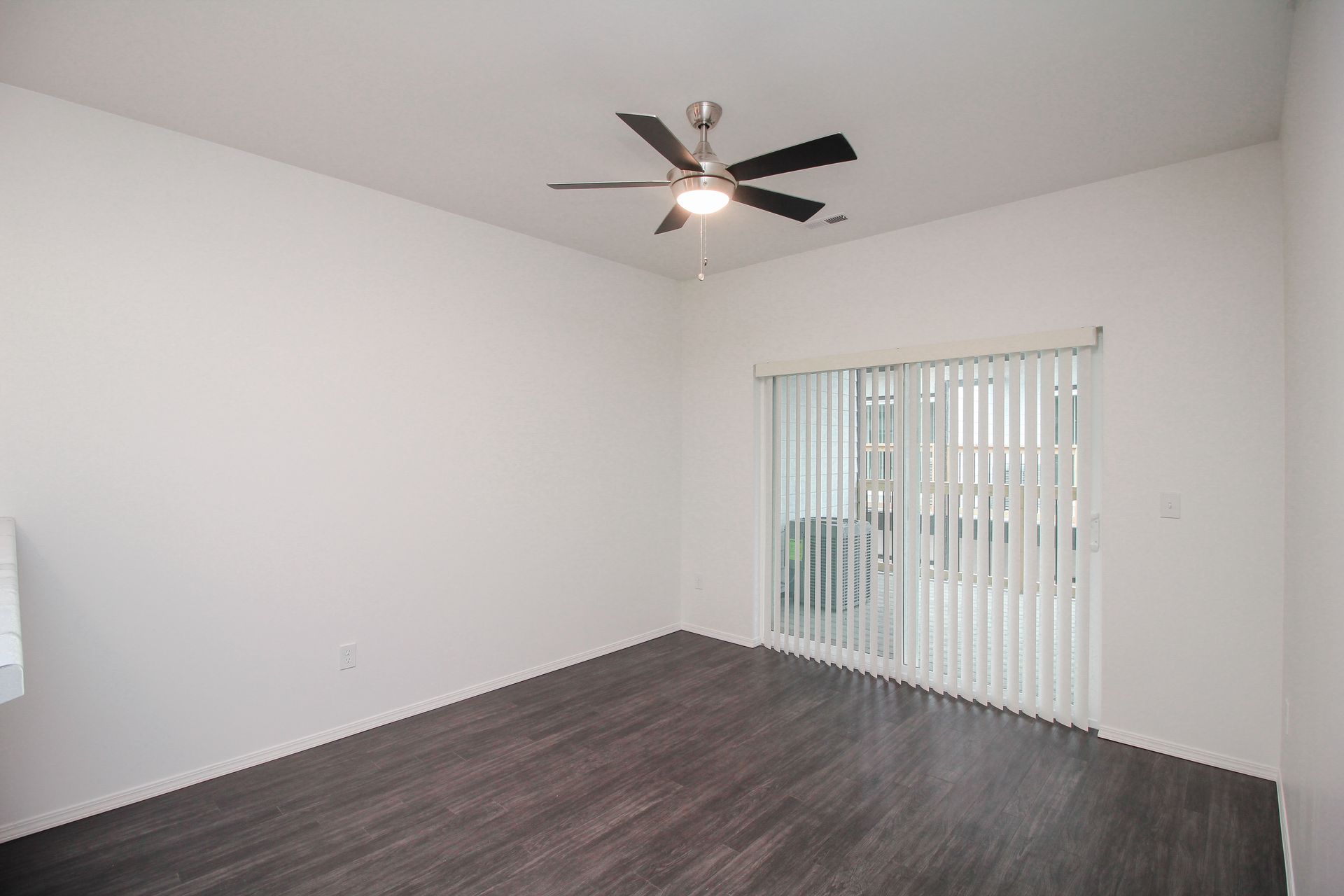 Empty white bedroom with carpet, closet doors, and a doorway to a bathroom.