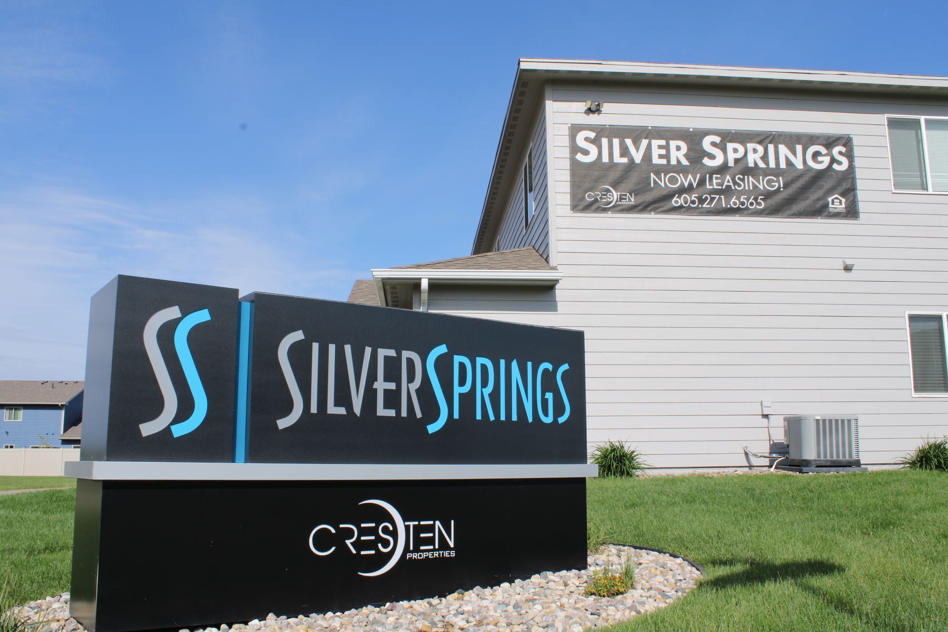 Silver Springs New Albany sign beside a white building and grassy lawn