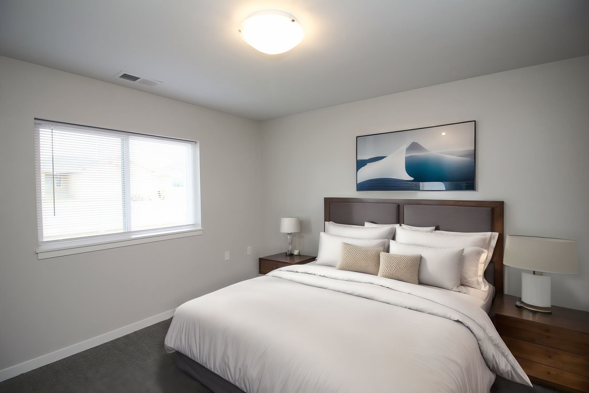 Modern bedroom with a bed, nightstands, ocean wall art, and a window with blinds.