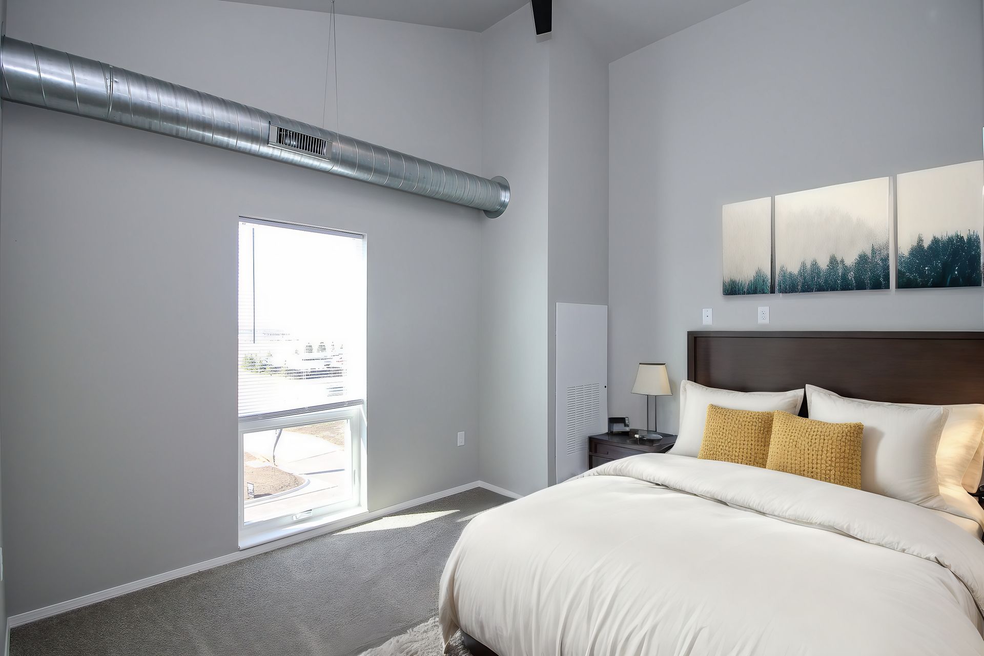 Modern bedroom with a bed, wall art, and an open door to a bright balcony
