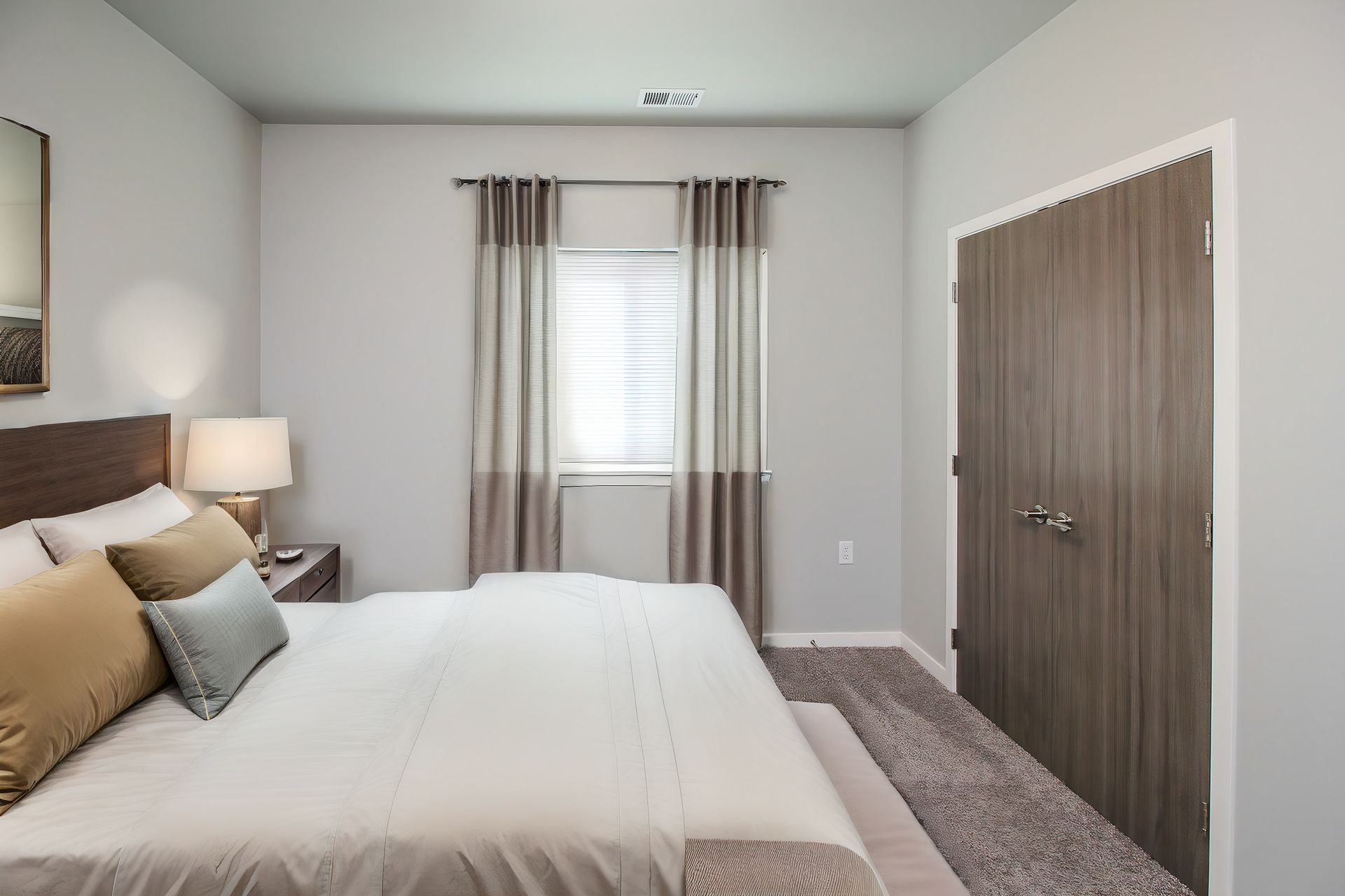 Modern bedroom with a bed, window with curtains, and double closet doors