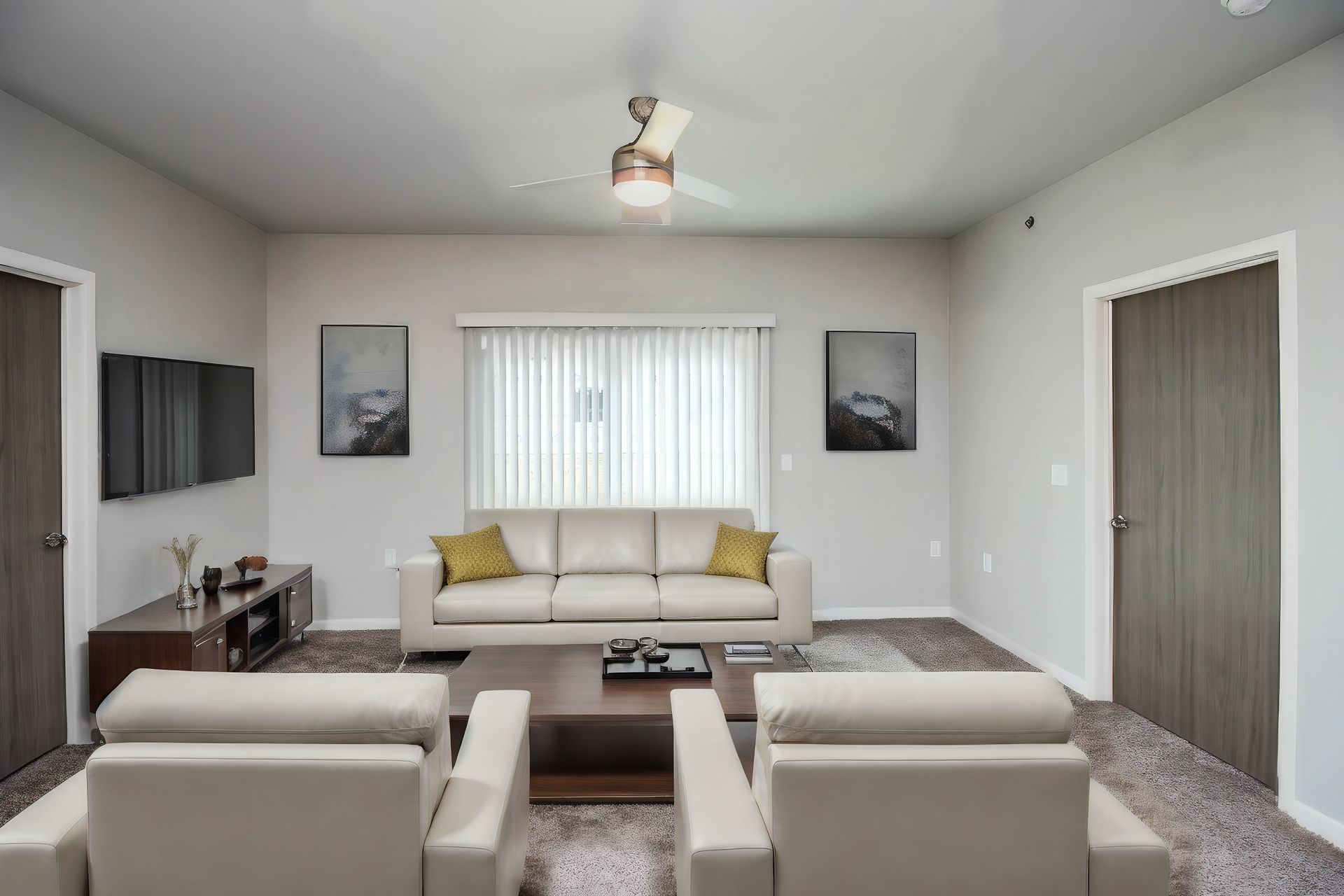 Modern living room with beige sofas, white walls, window blinds, and wall-mounted TV