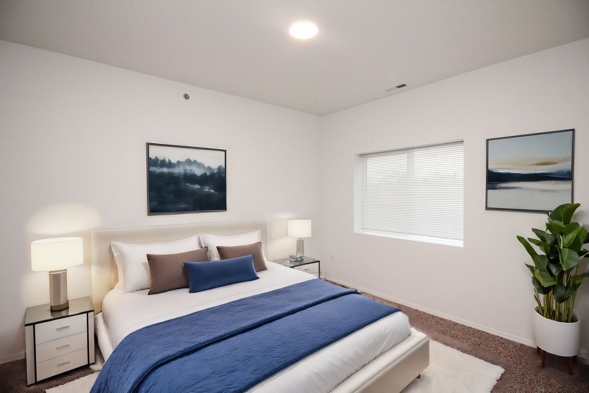 Bright modern bedroom with a neatly made bed, white walls, lamps, and a window with blinds