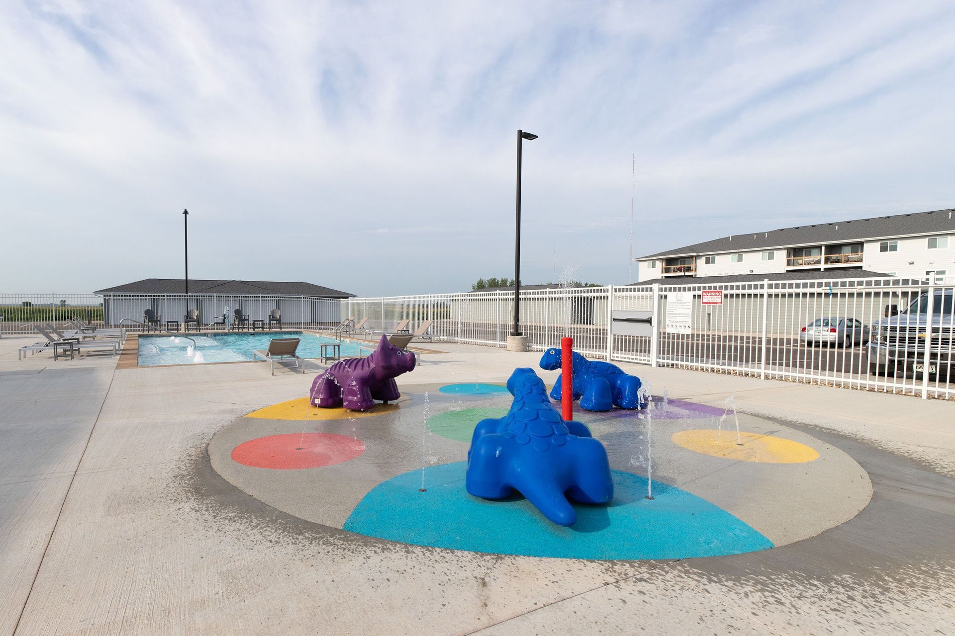 Colorful animal sculptures on a seaside playground near a fenced promenade