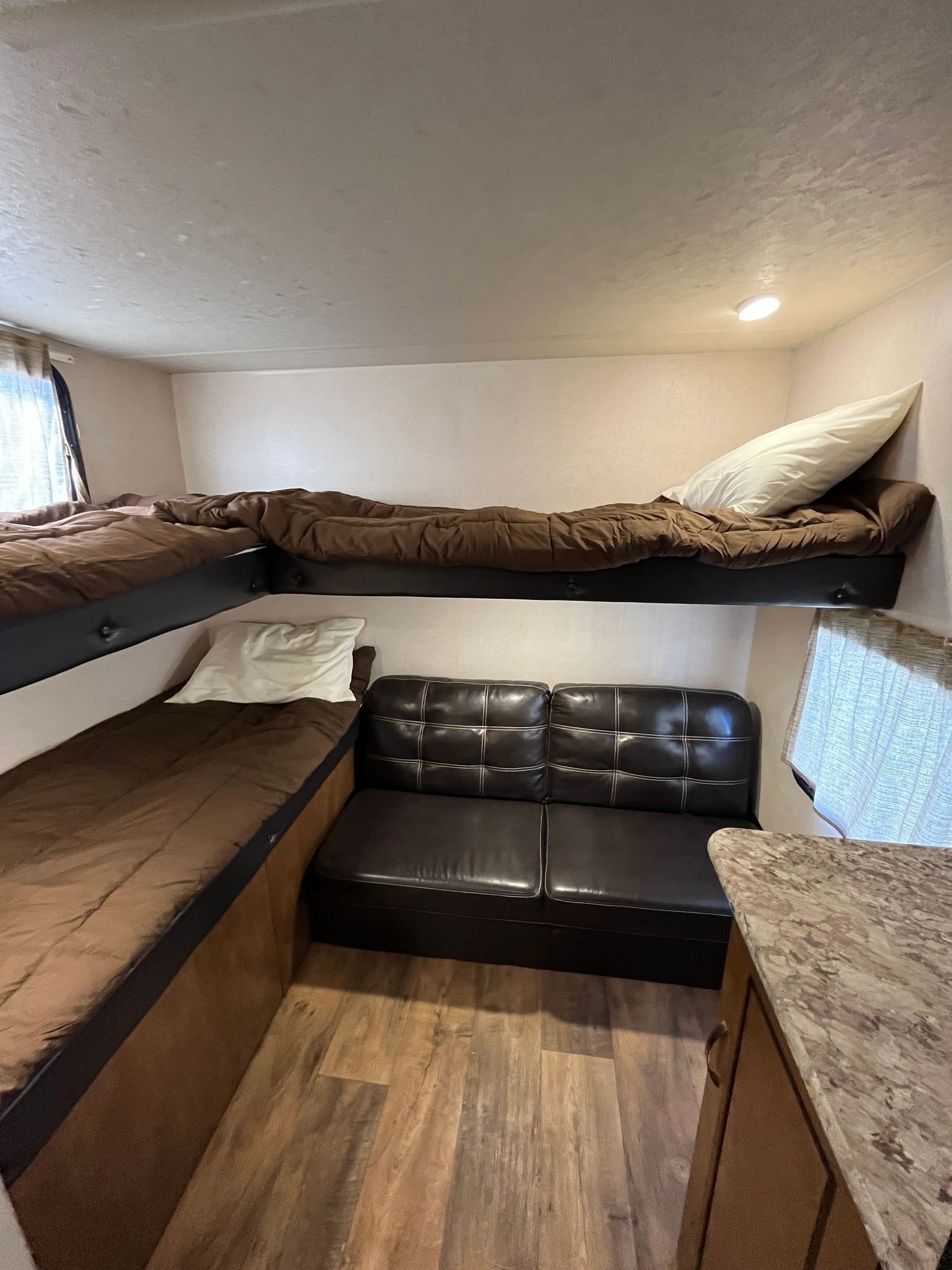 A small room with bunk beds and a couch.
