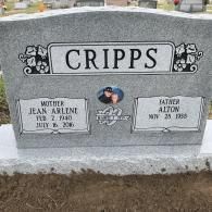 A gray granite headstone for the Cripps family with inscriptions for Jean Arlene and Alton, featuring a centered photo.