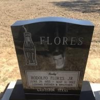 Black headstone for Rodolfo Flores Jr. (1983–2013) featuring a Coca-Cola bottle etching and a photo portrait.