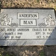 A grey stone memorial marker for Paul Robert Anderson (1946–1949) and Charles Ray Bean (1943–1943) with angel motifs.